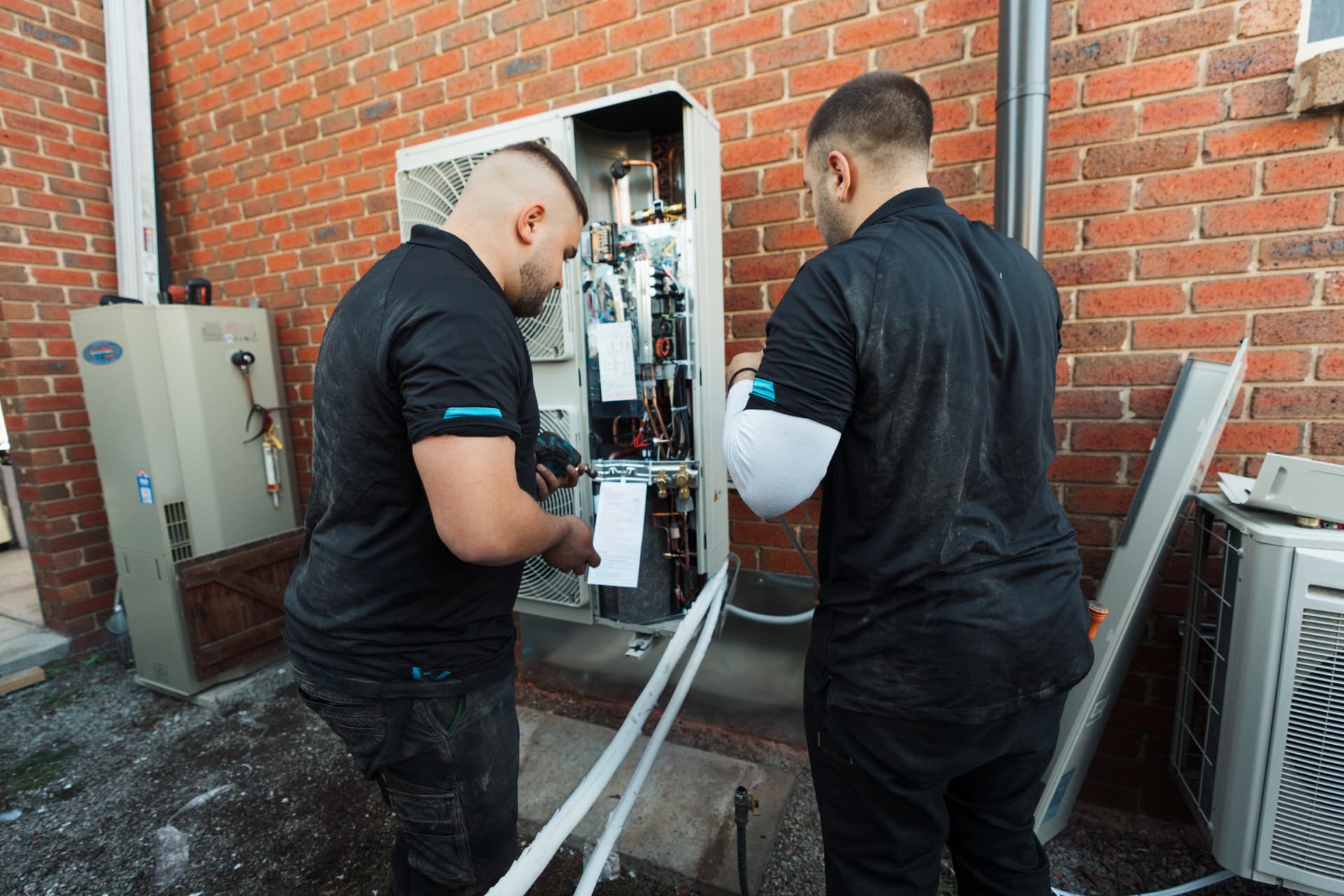 OneWorld EcoSolutions technicians installing air conditioning equipment at a Melbourne home