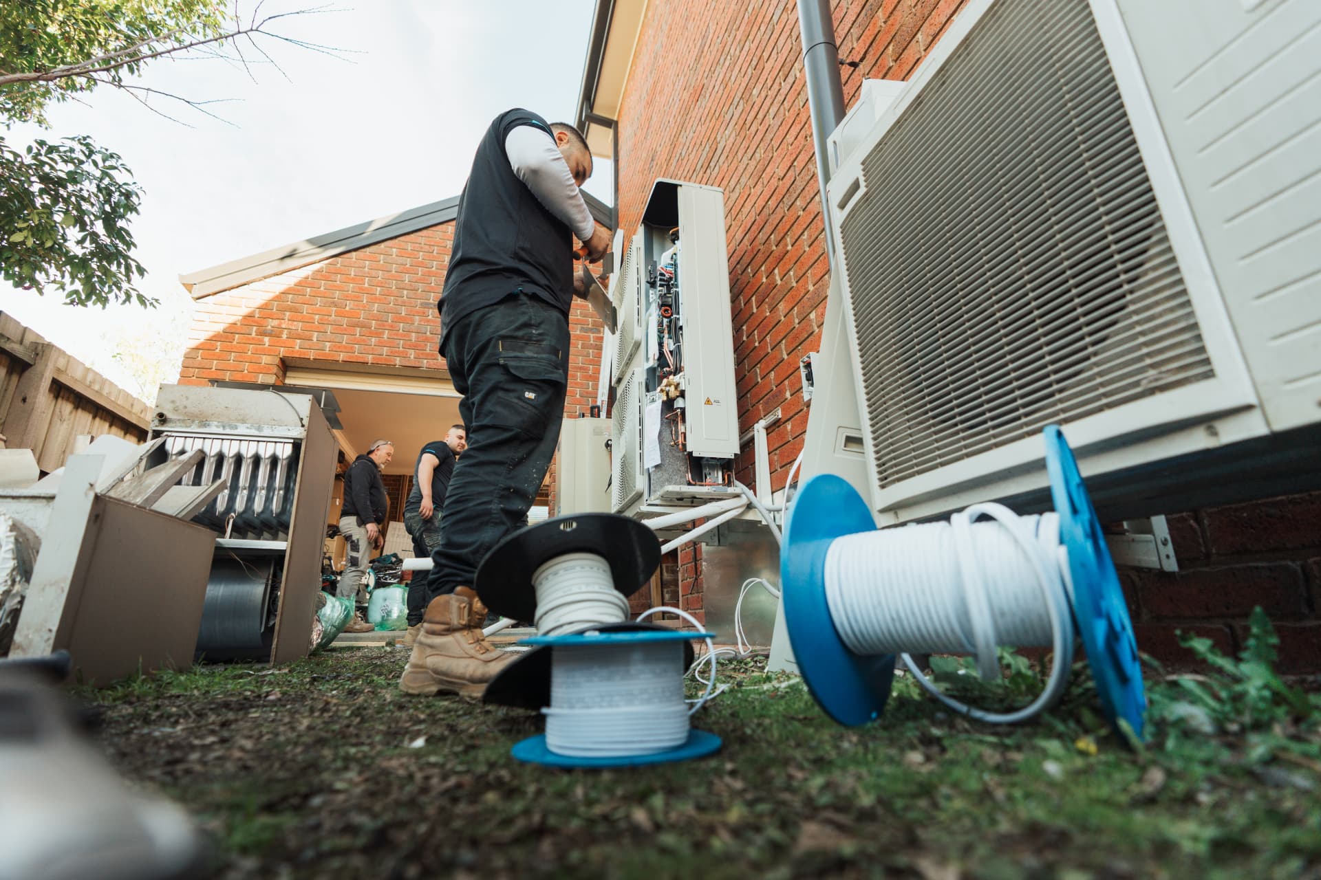 OneWorld EcoSolutions technician installing an outdoor air conditioning system